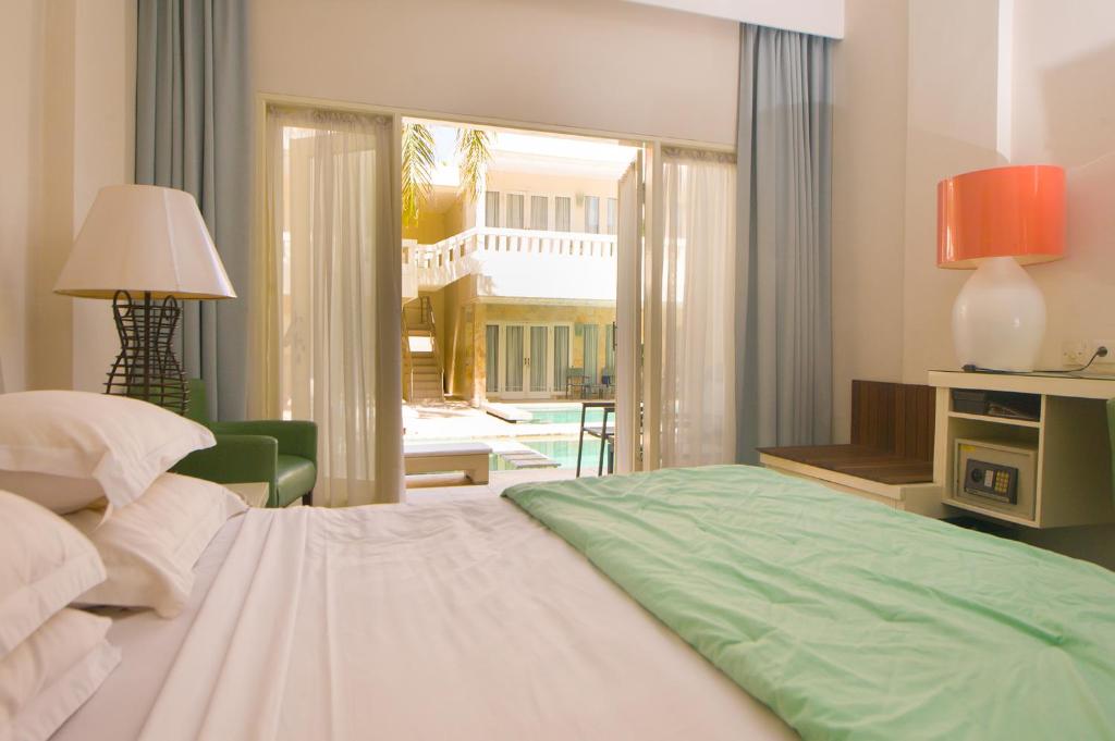 sypialnia z łóżkiem i pokój z patio w obiekcie Bali Court Hotel & Apartment w mieście Legian