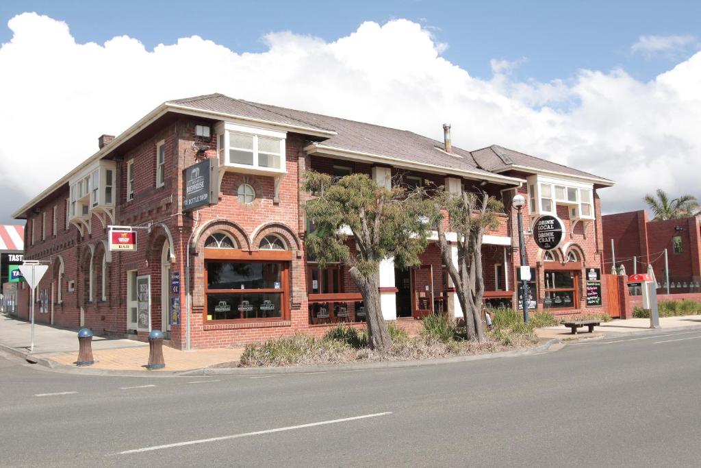 a large brick building with a clock on the side of it at Great Ocean Road Brewhouse Apollo Bay in Apollo Bay