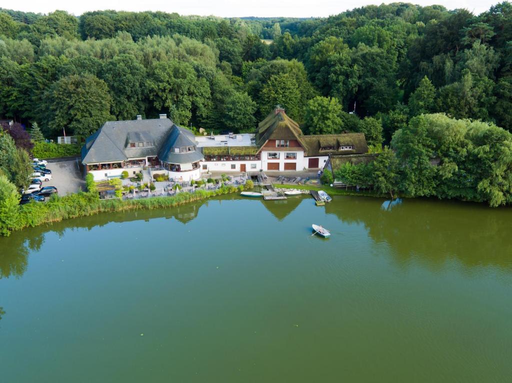 uma vista aérea de uma grande casa num lago em Fischerklause am Lutjensee em Lütjensee