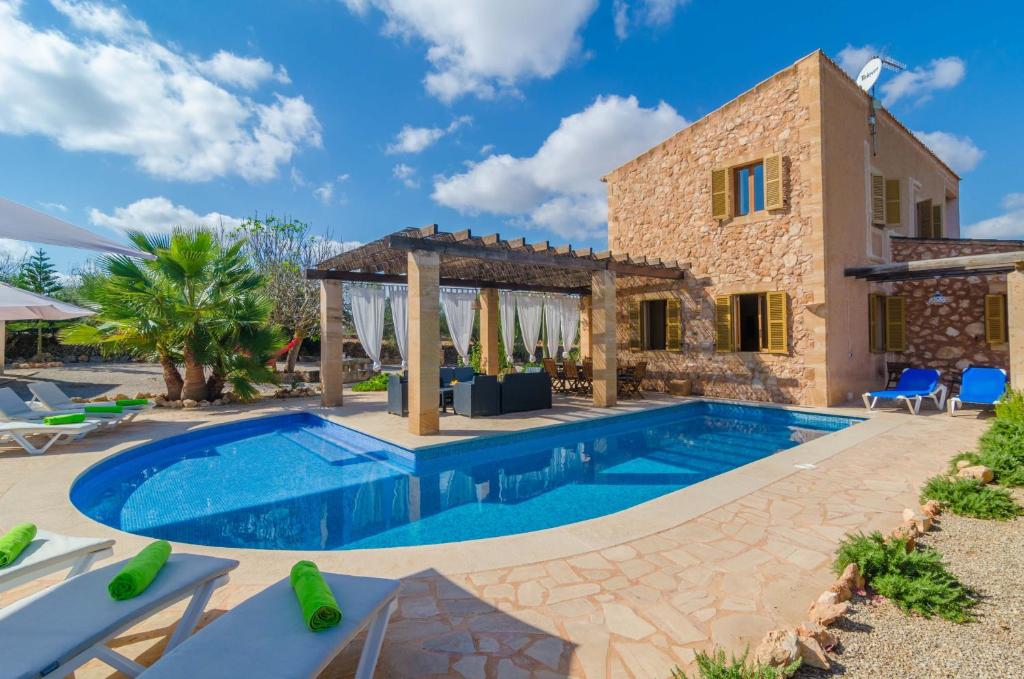 a villa with a swimming pool in front of a house at Ca Na Carme in Campos