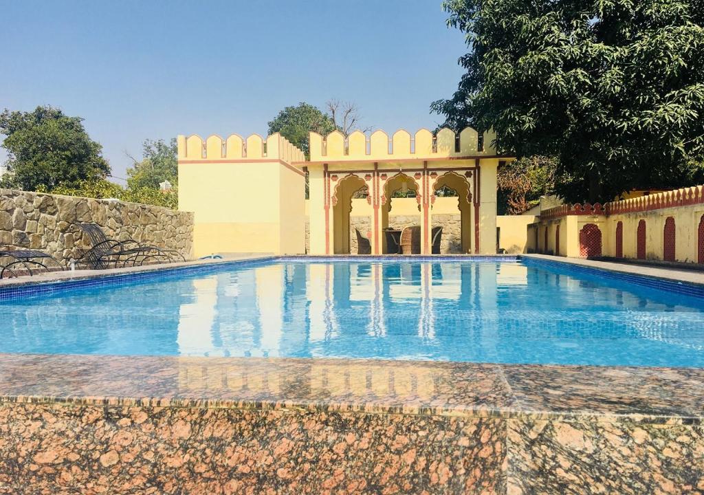a swimming pool in front of a building at Sajjan Bagh A-Heritage Resort in Pushkar