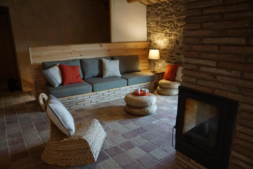 Mas Roca Del Mill في Perafita: غرفة معيشة مع أريكة ومدفأة