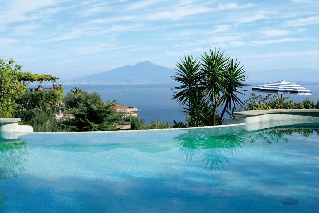 a swimming pool with a view of the ocean at Grand Hotel Capodimonte in Sorrento