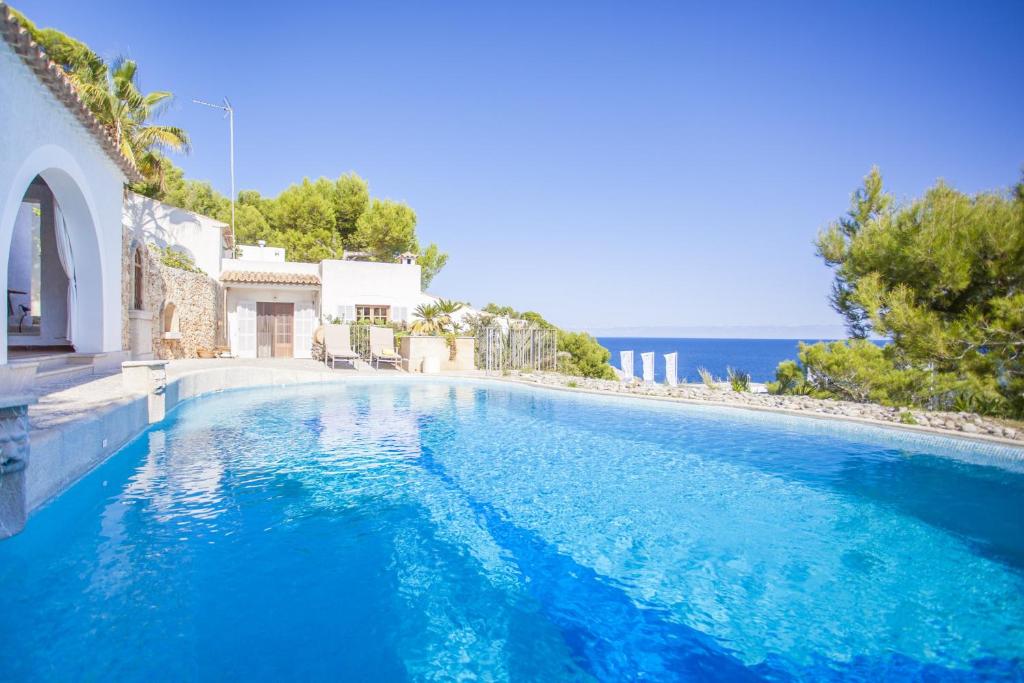 una piscina con acqua blu di fronte a una casa di Ram De Mar a Font de Sa Cala