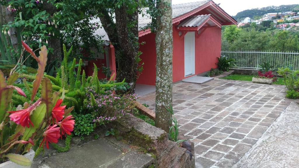 グラマドにあるSossego da Casa Vermelhaの赤い建物と花のある庭園