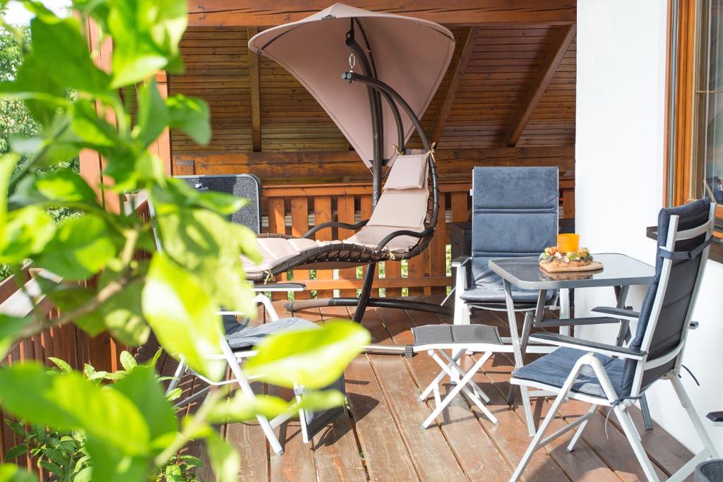 a patio with chairs and a table and an umbrella at Auszeit-Wohnungen in Aidenbach