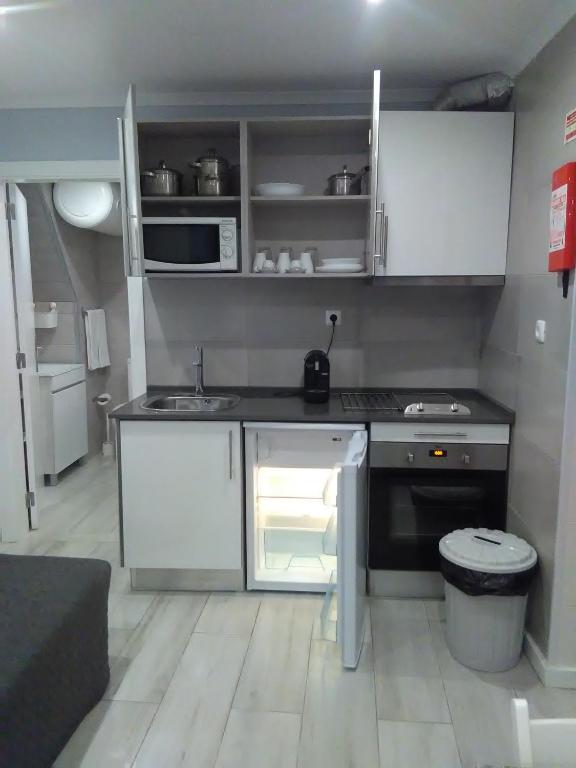a small kitchen with a stove and a refrigerator at Sao filipe Studio by Casas de Setúbal in Setúbal