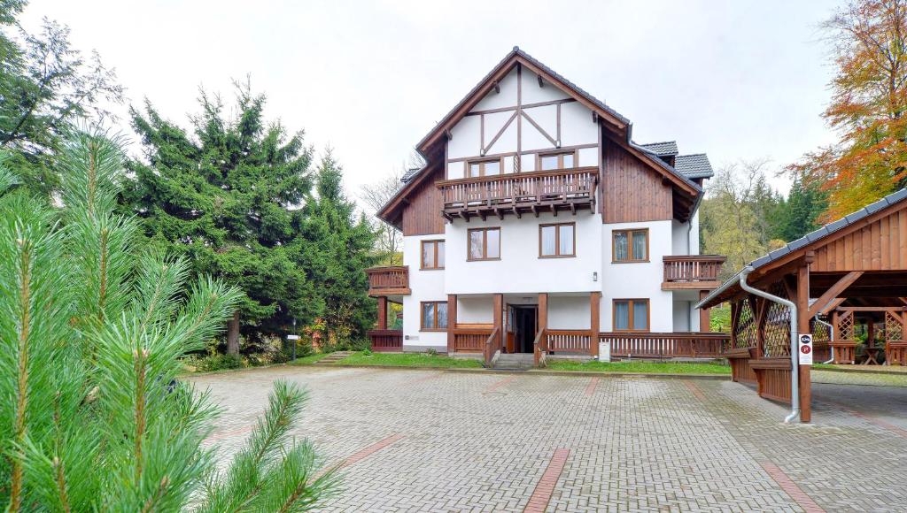 a large white house with a balcony on it at Apartamenty Sun Seasons 24 - Skalne in Karpacz