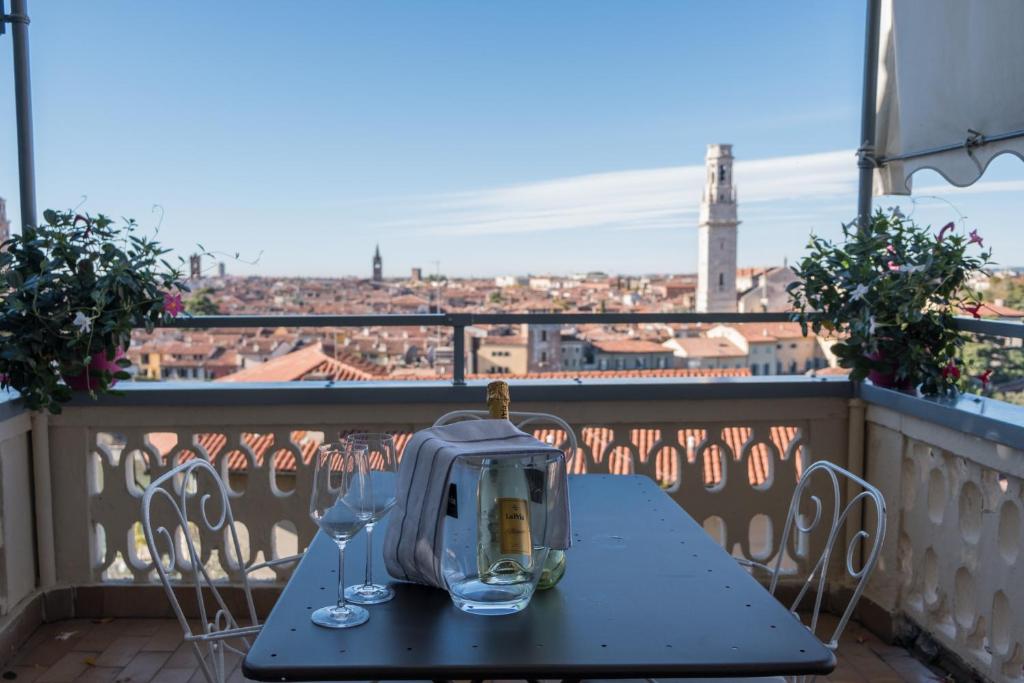 a table with wine glasses on a balcony with a view at Casa Corvina in Verona