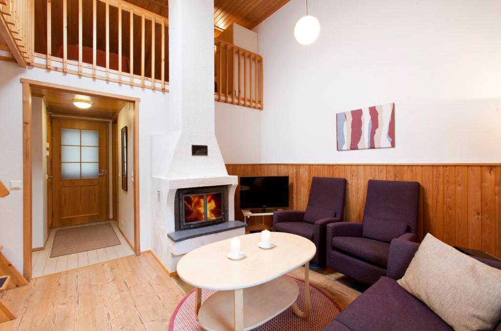 a living room with a couch and a fireplace at Holiday Club Pyhä Apartments in Pyhätunturi