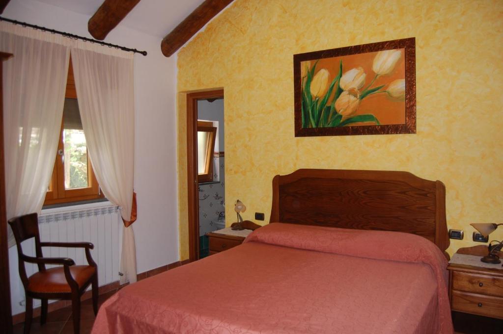 een slaapkamer met een bed, een tafel en een stoel bij Rabbit in Agerola