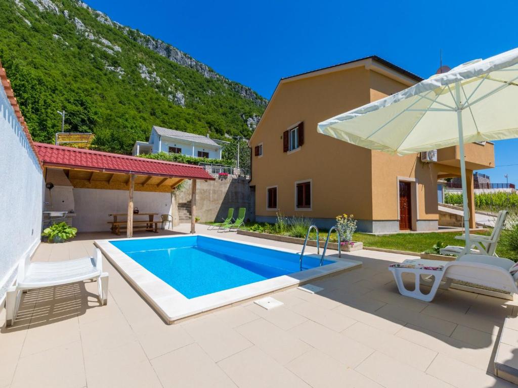 eine Villa mit einem Pool und einem Haus in der Unterkunft House Kapitulac in Grižane