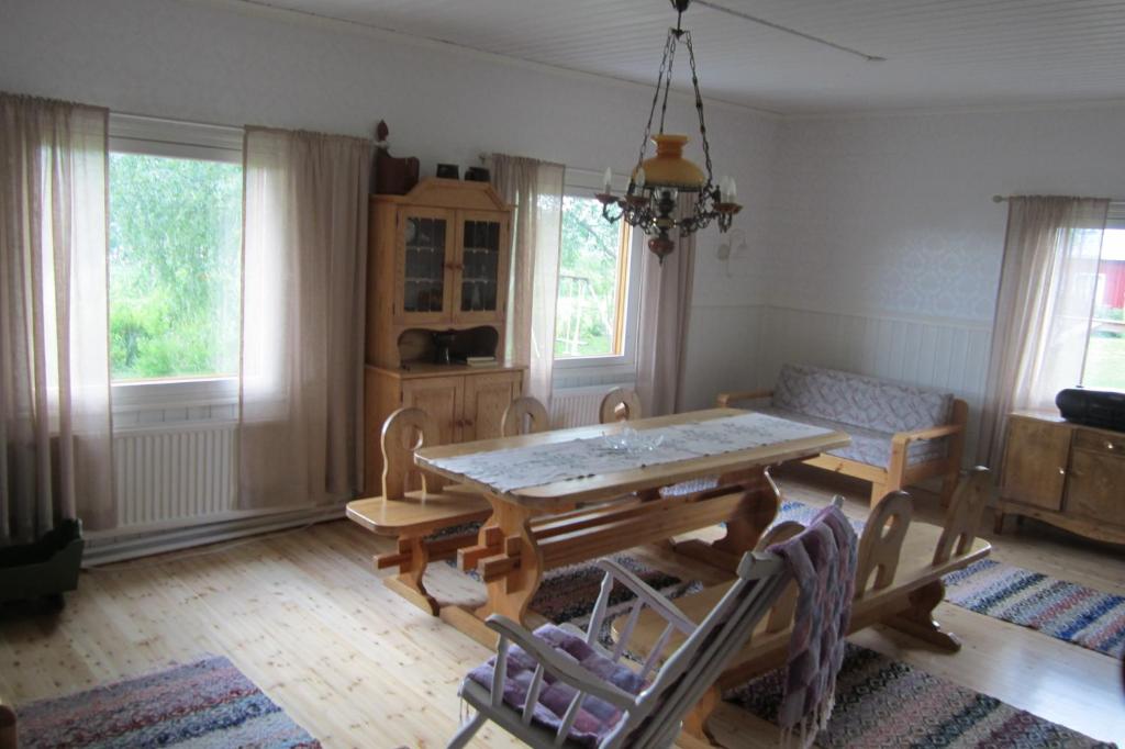 a dining room with a table and a couch at Ervastin Lomat in Heikkilä