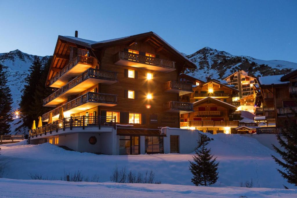 un gran edificio en la nieve por la noche en Mountain Lodge, Les Crosets en Les Crosets