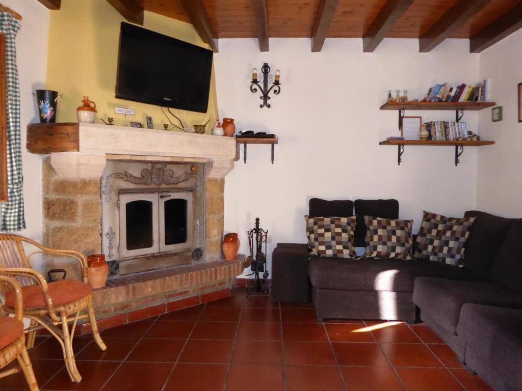 sala de estar con sofá y chimenea en Casa Rural Rudron, en Valdelateja