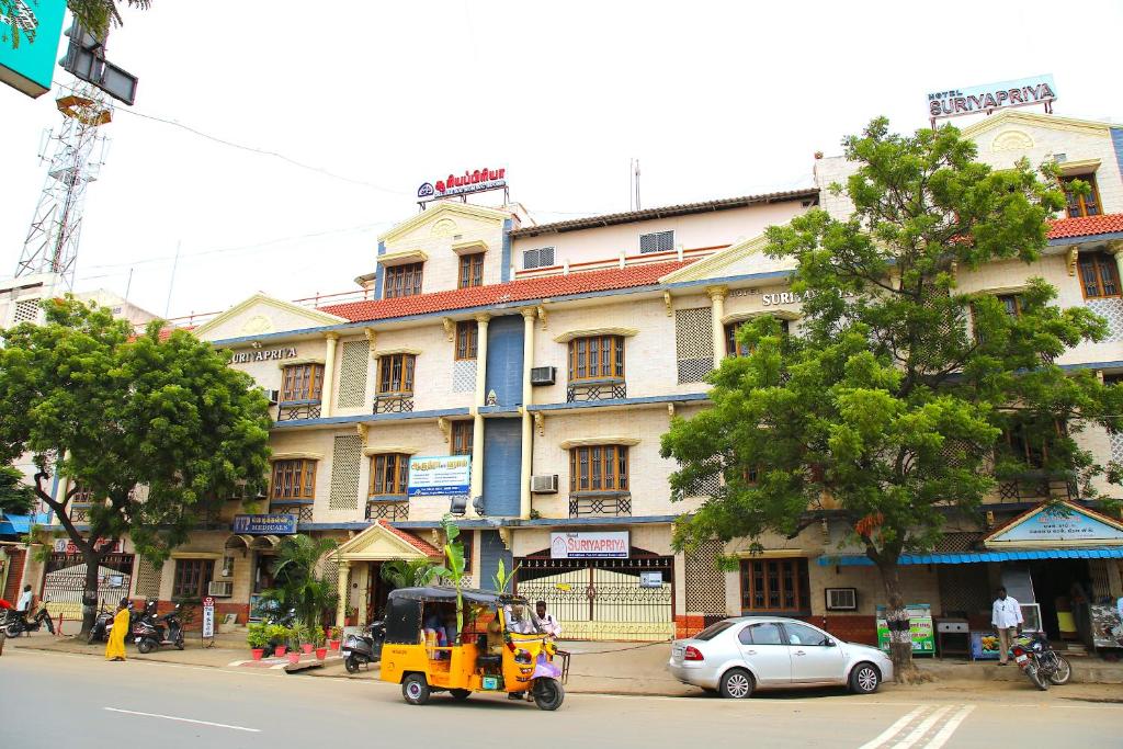 a yellow vehicle parked in front of a building at Hotel Suriyapriya in Cuddalore