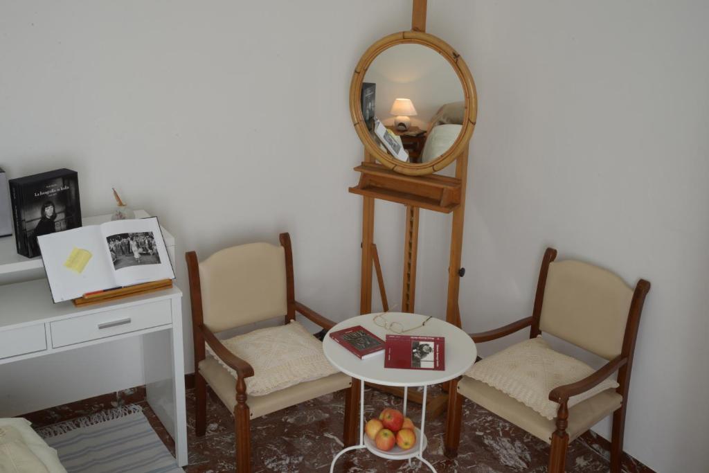 Habitación con 2 sillas, mesa y espejo. en L'incrocio - Bed&Breakfast en Imola