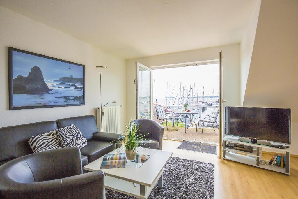 ein Wohnzimmer mit einem Sofa und einem TV in der Unterkunft Ferienwohnungen Marina in Großenbrode