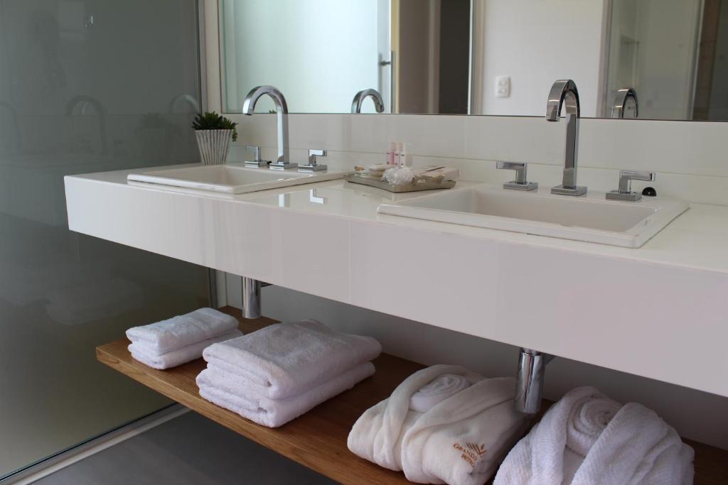 a bathroom with a counter with two sinks and towels at Grande Hotel Petrópolis in Petrópolis