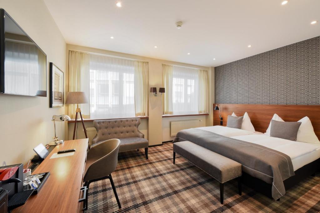 a hotel room with a bed and a desk at Hotel City Zürich Design & Lifestyle in Zurich