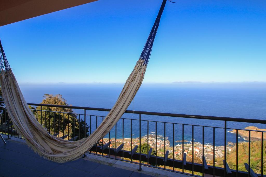 a hammock on a balcony overlooking the ocean at Paradise Ocean View by AnaLodges in Porto Moniz