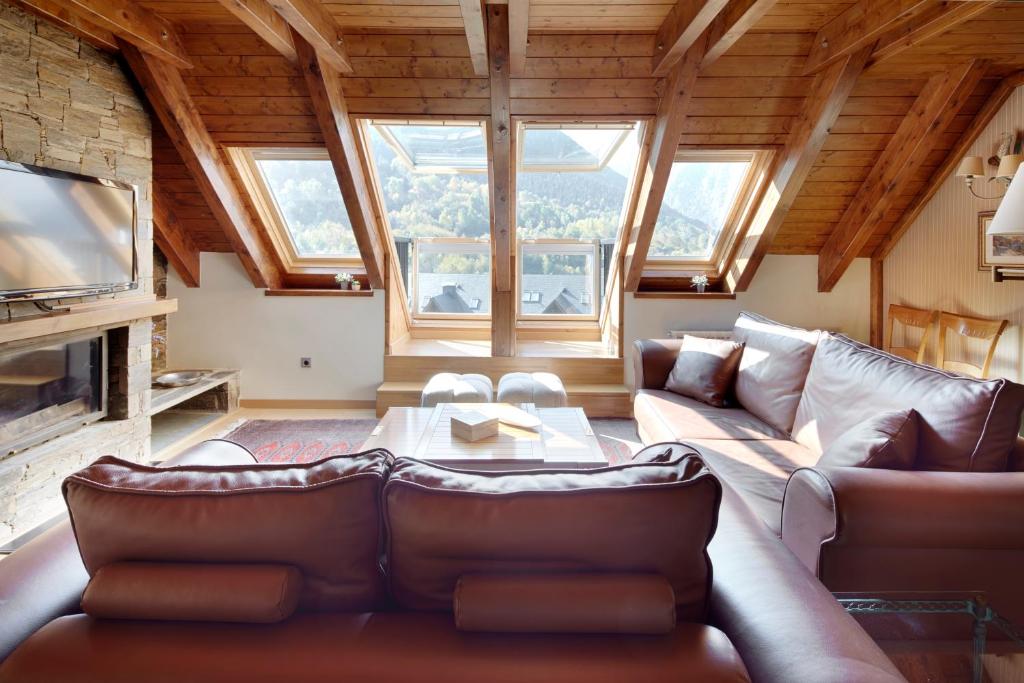 a living room with a leather couch and a tv at Prat de Gessa by FeelFree Rentals in Baqueira-Beret