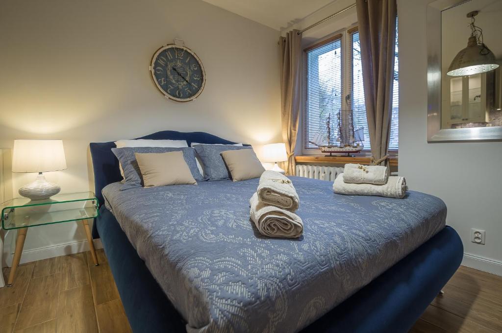 a bedroom with a blue bed with towels on it at Blue Boat Apartment Sopot in Sopot