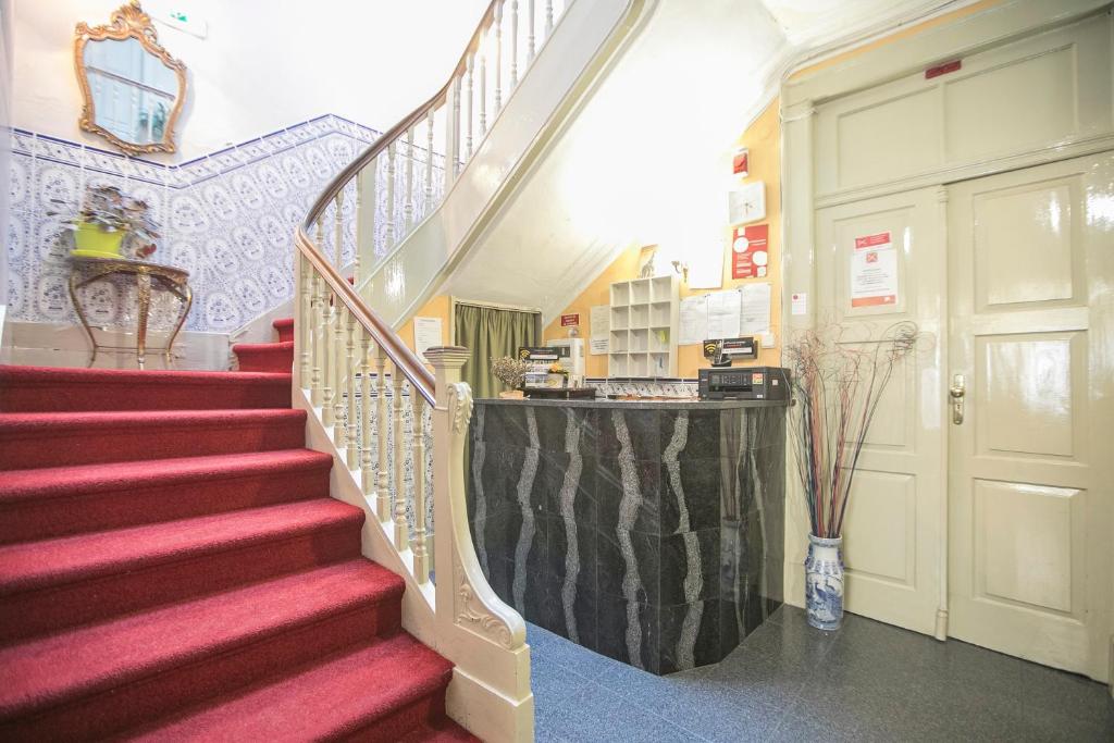 a staircase in a building with red carpeting and a door at Veneza in Porto