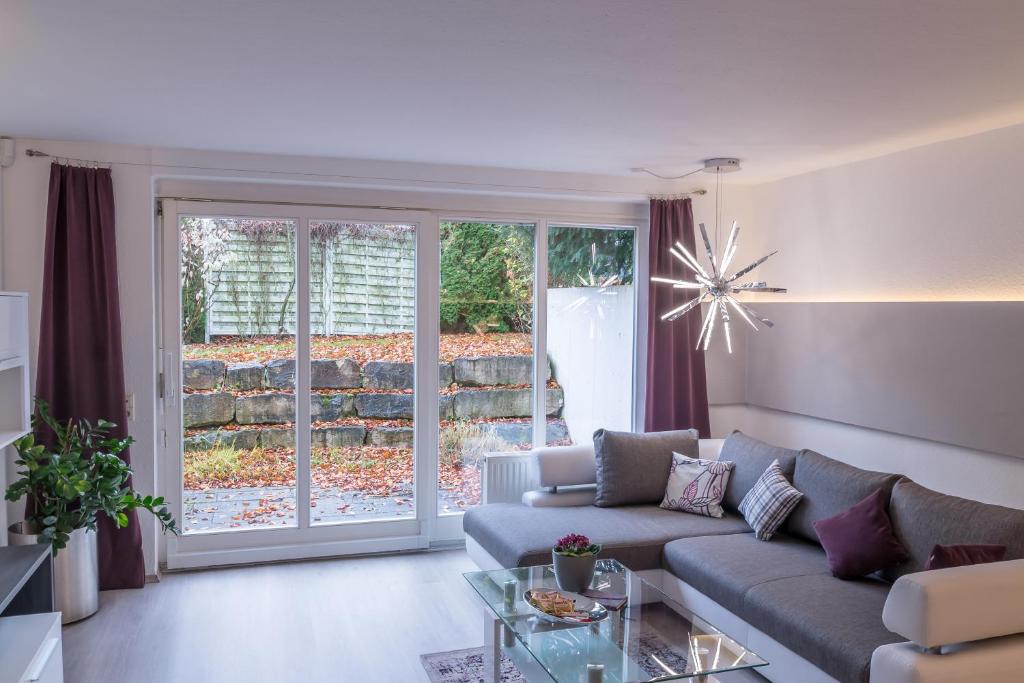 a living room with a couch and a glass table at Ruhiges und zentral gelegenes Apartment in Rosenfeld