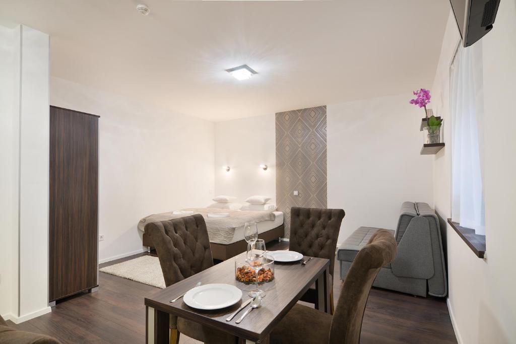 uma sala de jantar com uma mesa e cadeiras e uma cama em Paulay Downtown Apartments em Budapeste