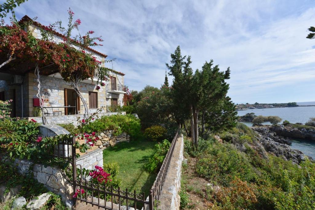 a house on the side of a hill with flowers at Anastasia Apartments in Stoupa