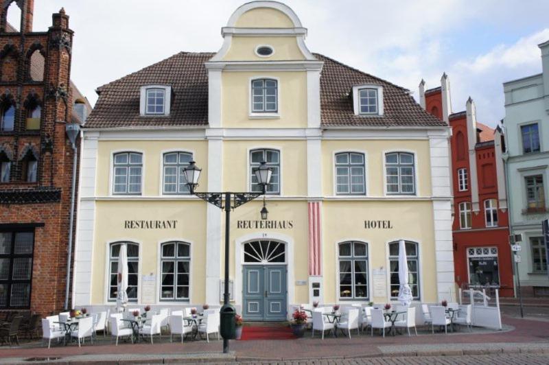 un edificio con tavoli e sedie di fronte ad esso di Hotel Reuterhaus Wismar a Wismar