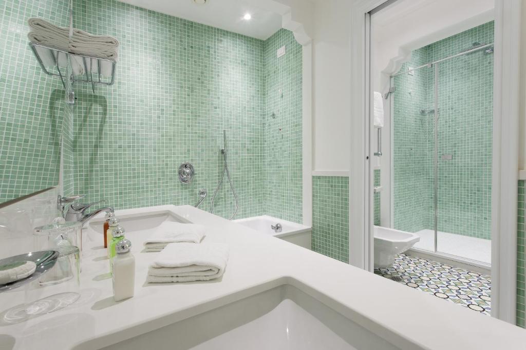 a white bathroom with a sink and a shower at Grand Hotel Ambasciatori in Sorrento