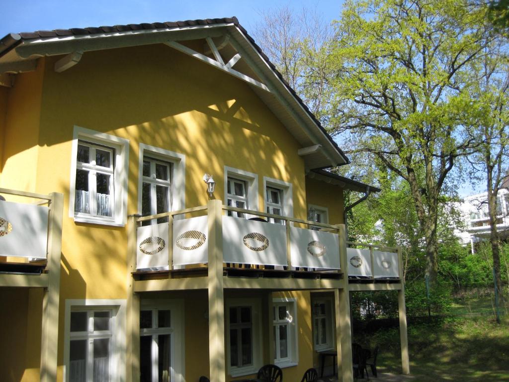 een geel huis met een balkon aan de zijkant bij Ferienwohnung Familie Böckmann im Ostseebad Zinnowitz auf Usedom in Zinnowitz