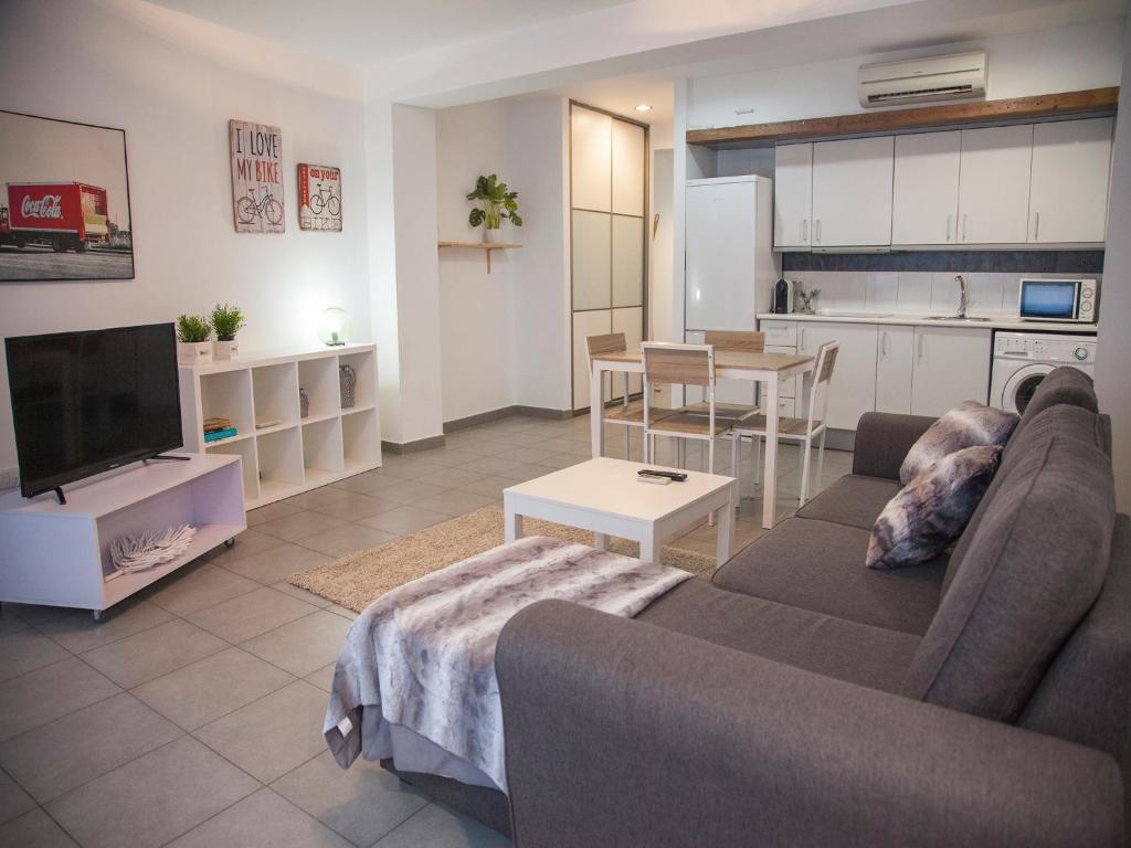 ein Wohnzimmer mit einem Sofa und einem Tisch sowie eine Küche in der Unterkunft Flats Friends Tetuan in Valencia