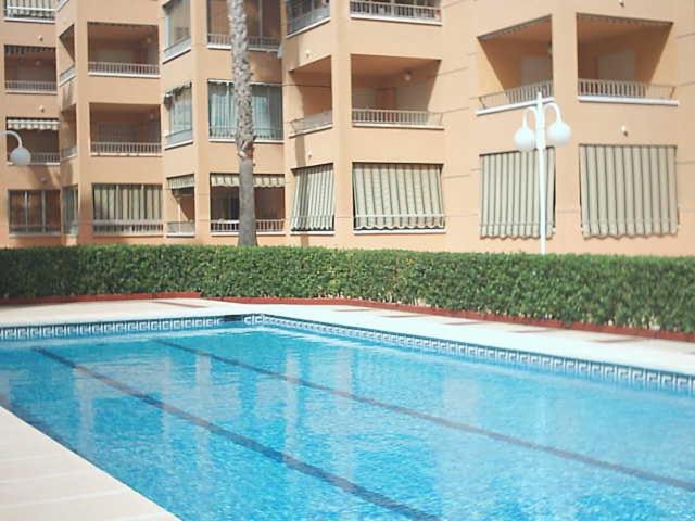 una piscina frente a un edificio de apartamentos en Apartamento Antillas, en Gandía