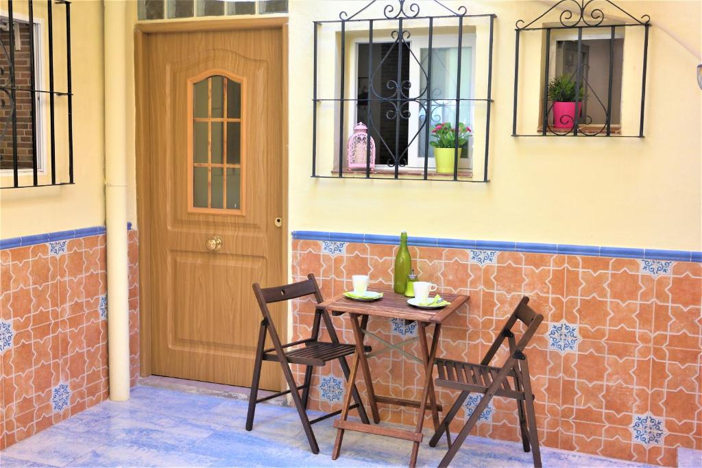 マラガにあるApartamento Barheloのドアの隣のパティオ(テーブル、椅子付)