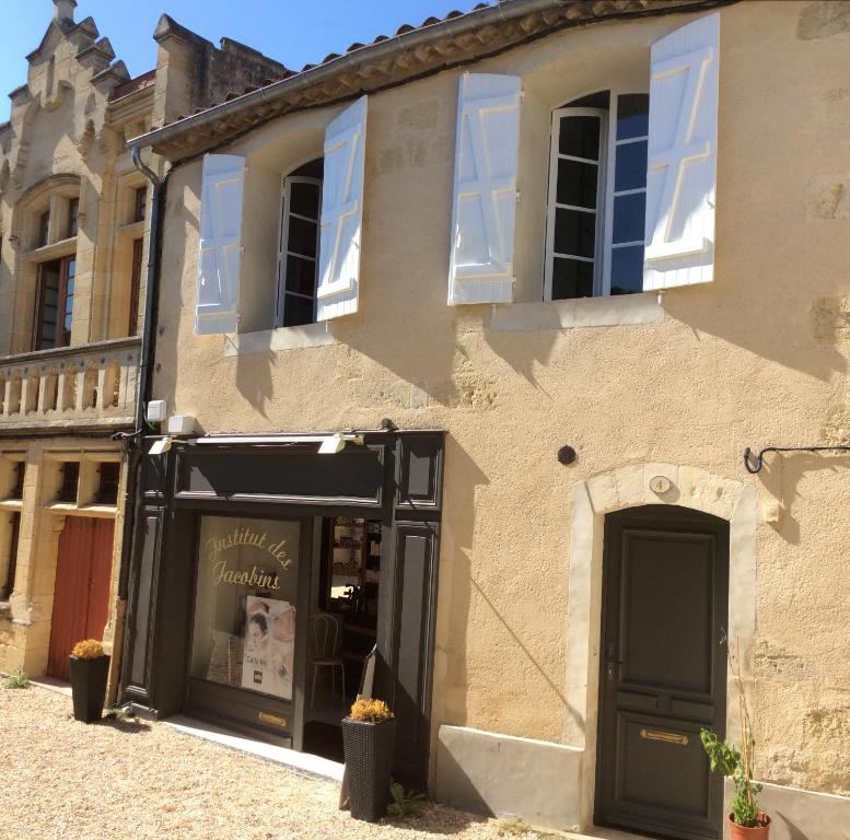 un negozio di fronte a un edificio con una porta nera di L'appart des Jacobins a Saint-Émilion