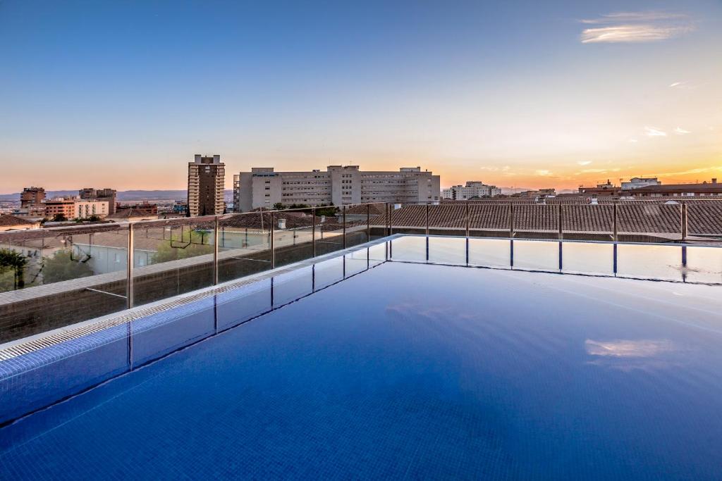 a swimming pool on top of a building with a city skyline at Allegro Granada in Granada