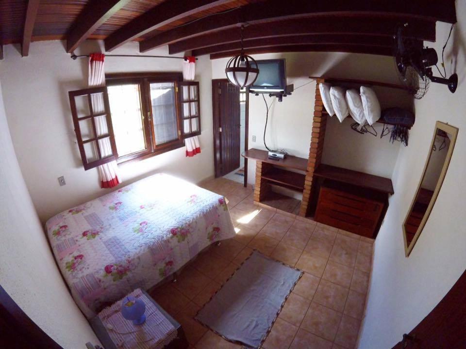 a bedroom with a bed and a desk in a room at Casa da Mayner in Trindade