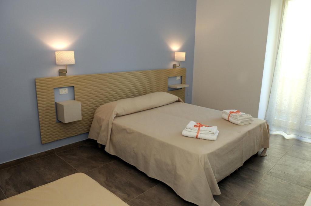 a bedroom with a bed with two towels on it at Della torre rooms in Lecce