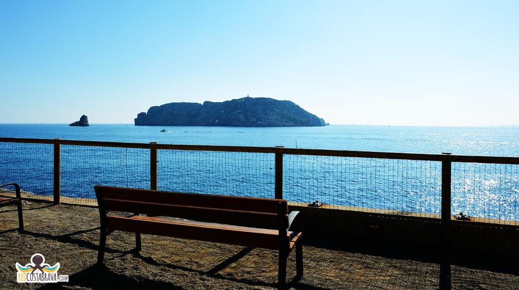 a bench sitting in front of the ocean at Apartment Medes Platja in L'Estartit