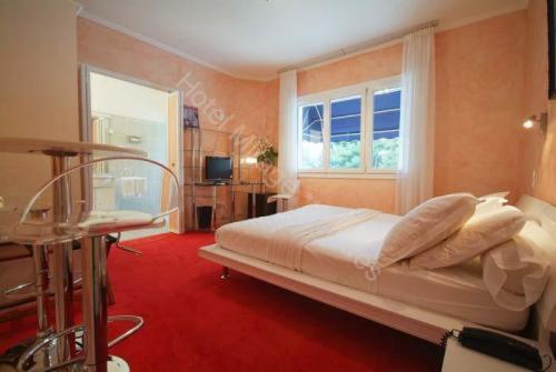 une chambre avec un grand lit et une fenêtre dans l'établissement Cit'Hotel Le Mirage, à Istres