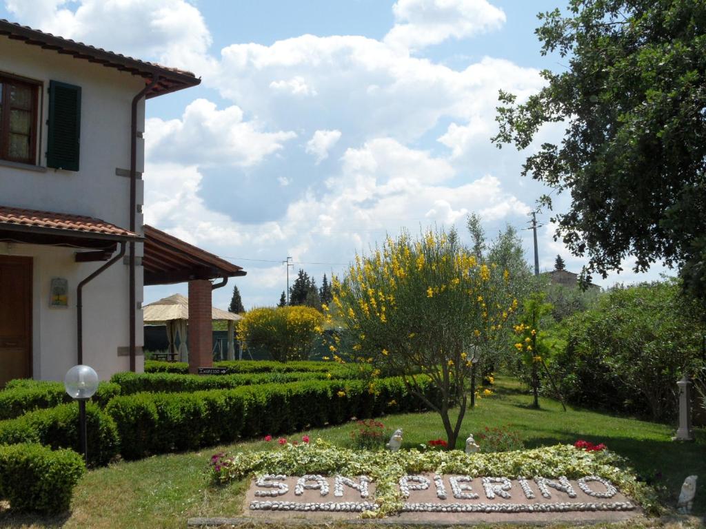 um jardim em frente a uma casa com uma placa em Podere San Pierino em Montelupo Fiorentino