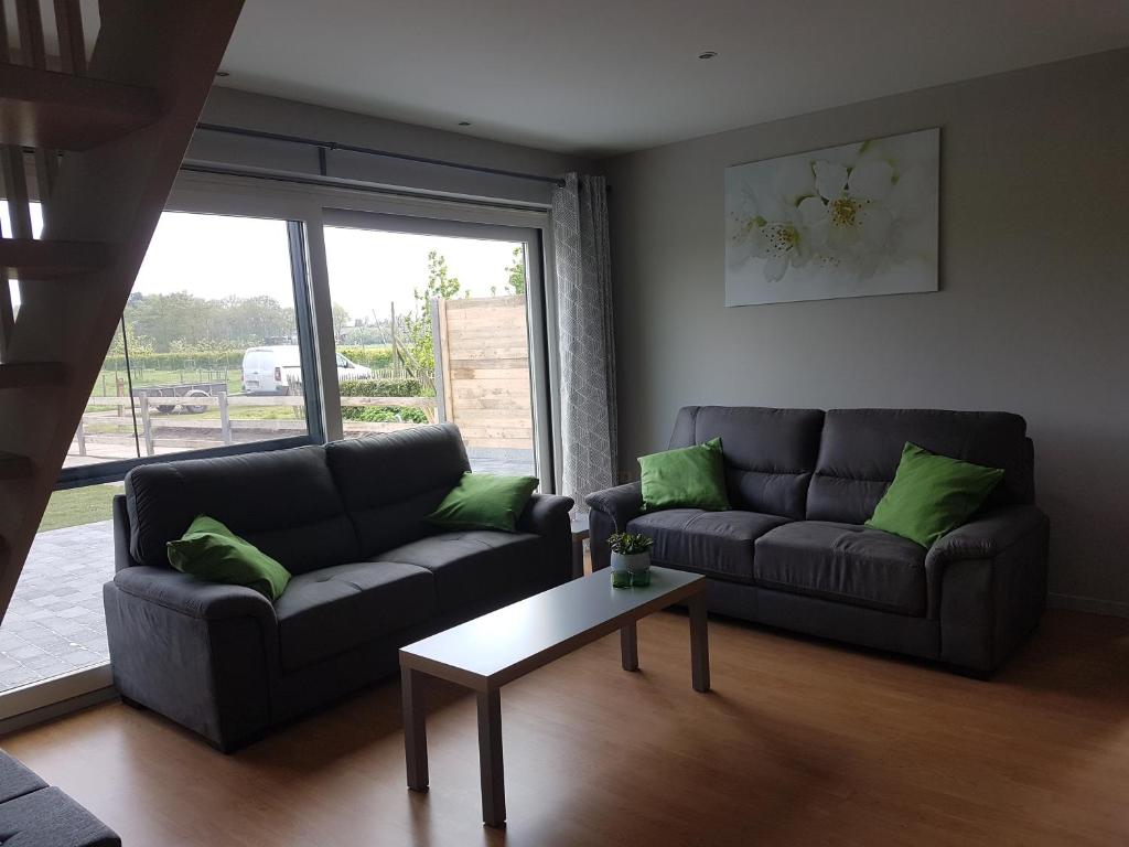 a living room with two couches and a coffee table at De Schaapskooi in Kasterlee