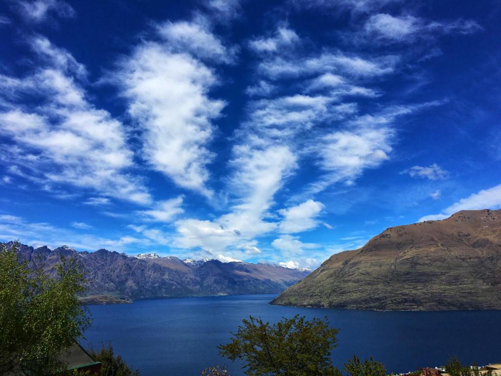 Blick auf einen großen Wasserkörper mit Bergen in der Unterkunft Awesomely Lakeview Queenstown Home in Queenstown