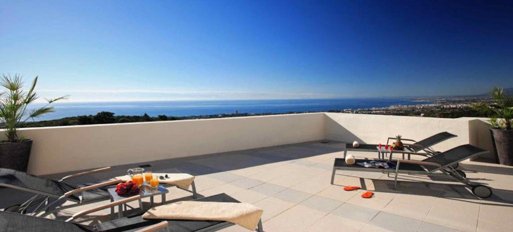 un patio con sillas y mesas en un balcón en Marbella Luxury Penthouse, en Marbella