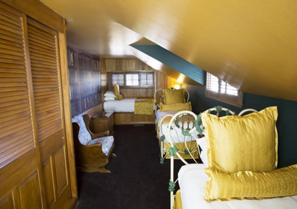 a train room with two beds and a couch and chairs at Madonna Inn in San Luis Obispo