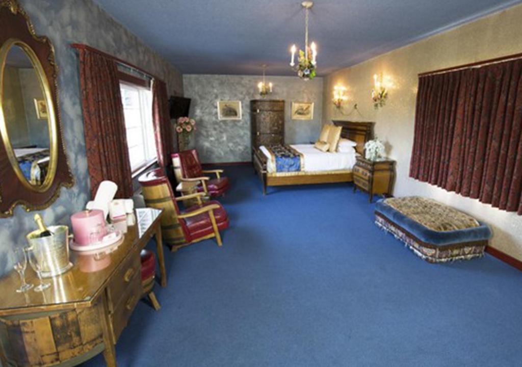a room with a bedroom with a bed and a mirror at Madonna Inn in San Luis Obispo