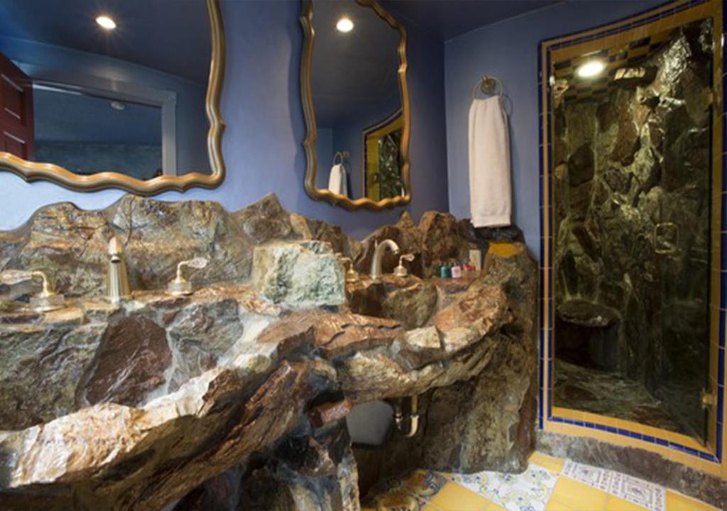a bathroom with a stone sink and a large mirror at Madonna Inn in San Luis Obispo